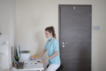 Canva - Young female doctor working with computer in modern clinic